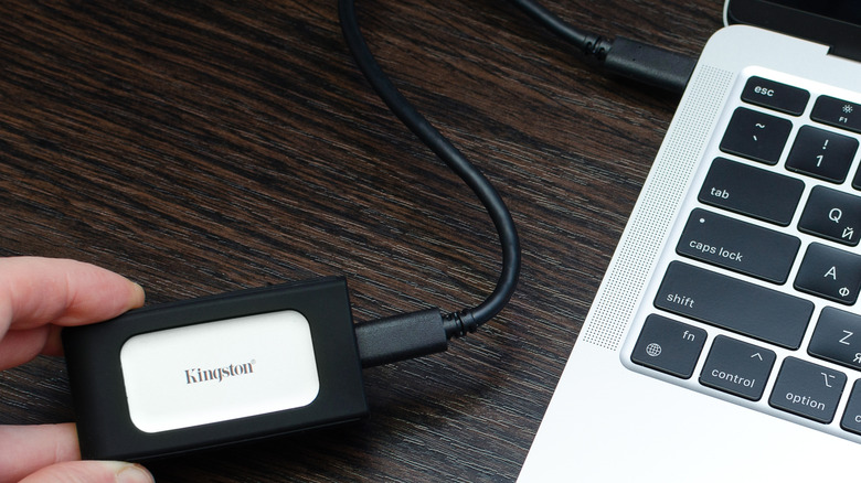 A high-performance external SSD connected to the USB-C port of a MacBook.