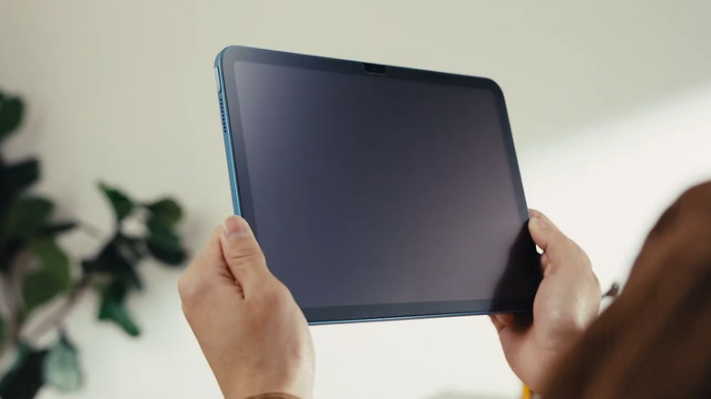 An iPad with a matte screen protector being held, showing the non-reflective surface.