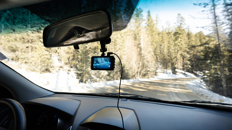 Interior view of a vehicle showing a dash cam recording the road ahead.