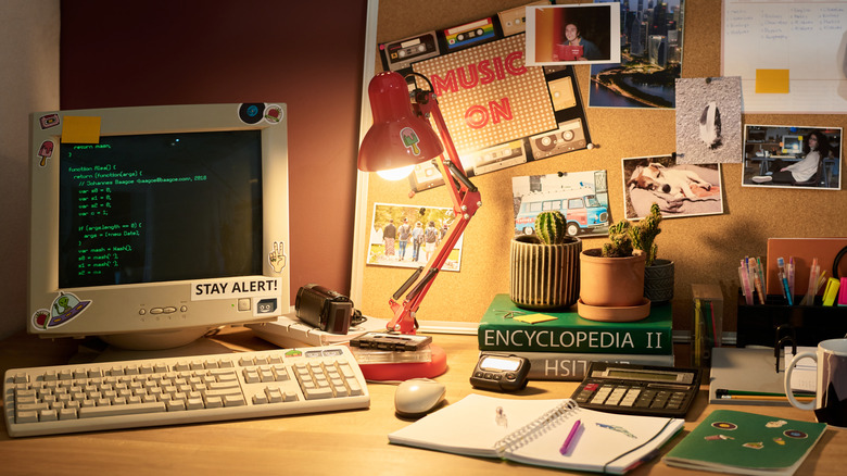 A vintage desk setup with an old-school computer, books, and retro accessories.