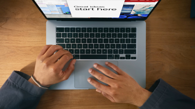 A student using a slim MacBook Air in a casual setting.