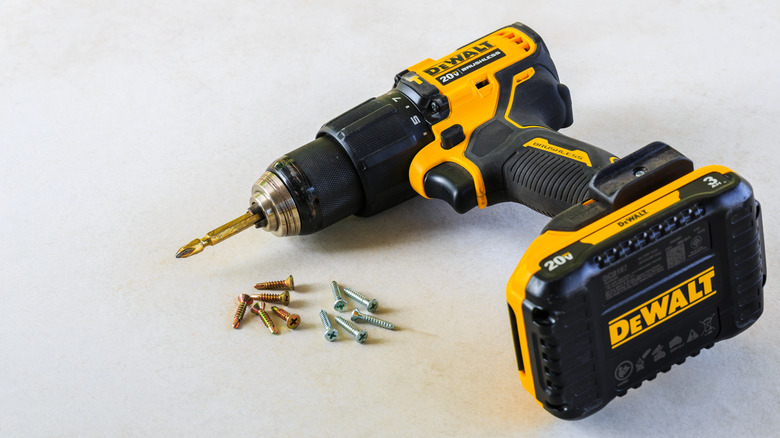 A yellow and black DeWalt hammer drill positioned on a cement board surface.