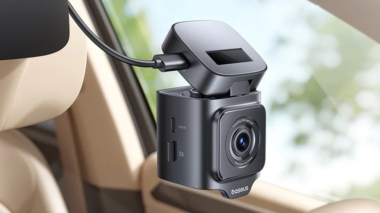 Baseus VD1 Pro front camera unit installed near the rearview mirror of a car.