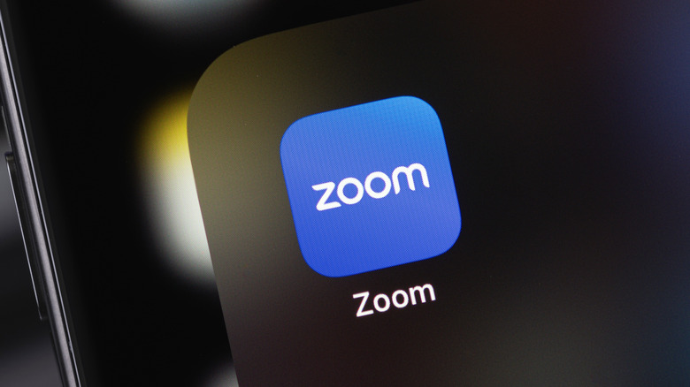 The Zoom app icon on a smartphone, representing its audio-only integration with Apple CarPlay.