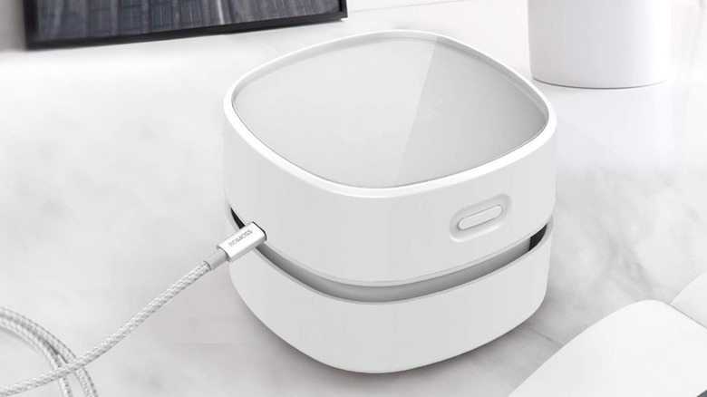 A compact white Odistar Desktop Vacuum Cleaner on a desk surface.