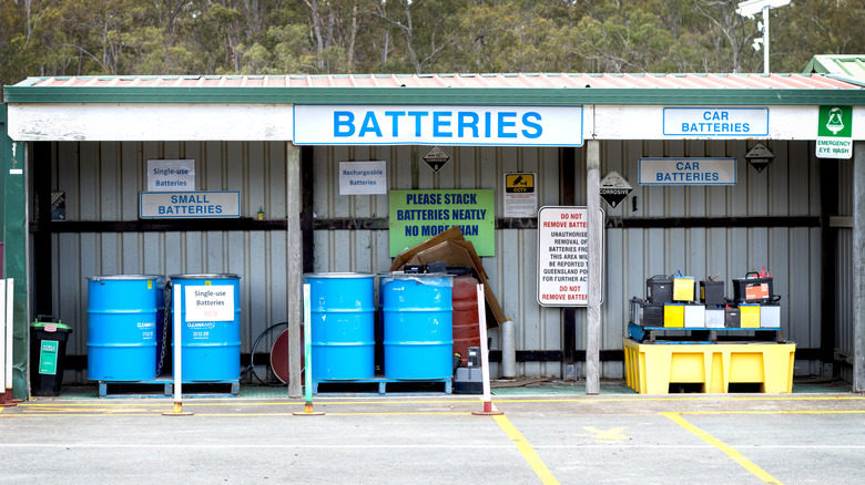 Several recycling bins at a collection center labeled for different battery chemistries including rechargeable cells.