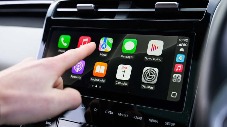 A driver using hands-free controls to interact with the Apple CarPlay display in their vehicle.