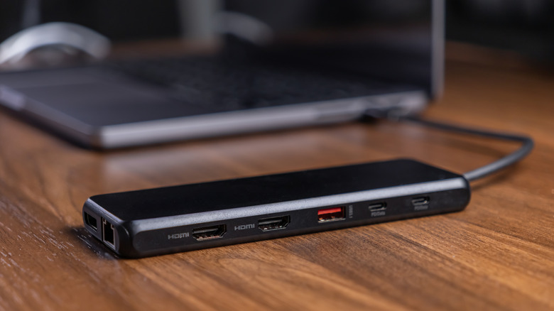 A multi-port USB hub connected to a laptop showing several cables plugged in.