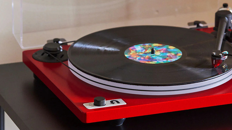 A bright red U-Turn Audio Orbit turntable playing a vinyl record.