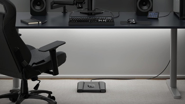 Elgato Stream Deck foot pedal with three customizable buttons positioned under a workspace desk.