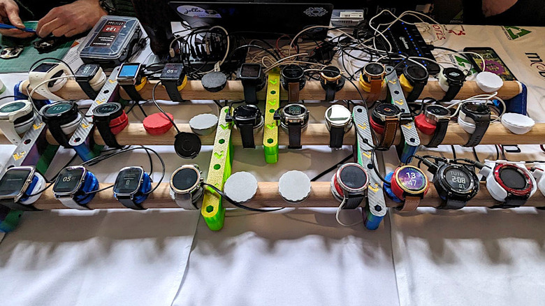 Multiple smartwatches running the AsteroidOS Linux-based operating system on display.