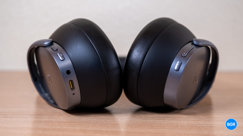 A close-up view of the memory foam padding and matte plastic ear cups of the Baseus XH1.