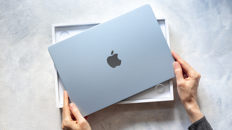 A new Apple MacBook Air being unboxed, showing its thin profile and premium finish.
