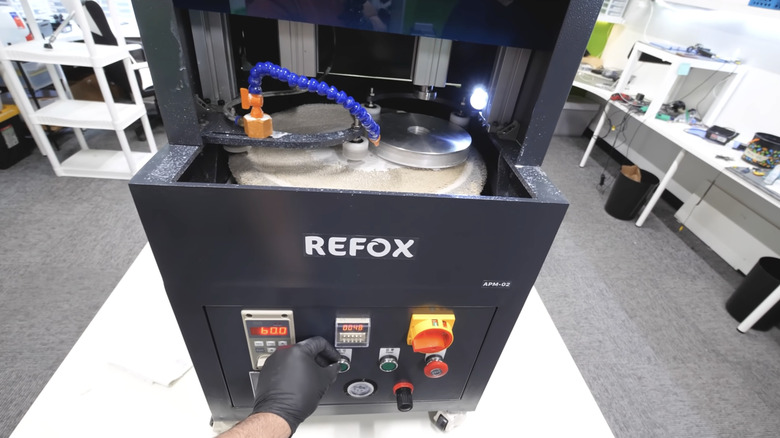 A Refox automatic screen polishing machine in a repair shop setting.