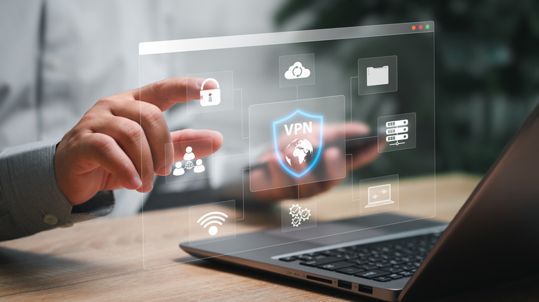 A close-up of a finger touching a lock icon on a VPN interface overlaying a laptop screen.