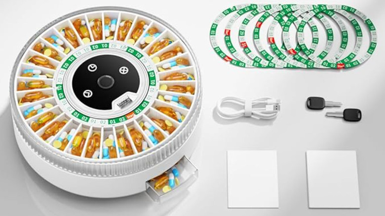 A smart pill dispenser sitting on a white table.