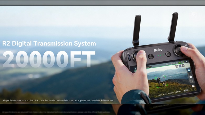 A close-up of a pilot holding the RC3 controller with its built-in telemetry screen during flight.