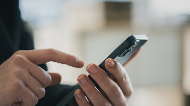 A person using a smartphone to interact with smart home devices.