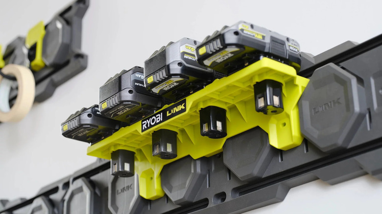 Ryobi batteries neatly organized on a Link One+ Battery Shelf mounted to a wall.