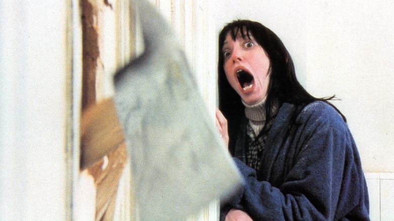 Wendy Torrance cowering in fear in a brightly lit, high-contrast bathroom scene.