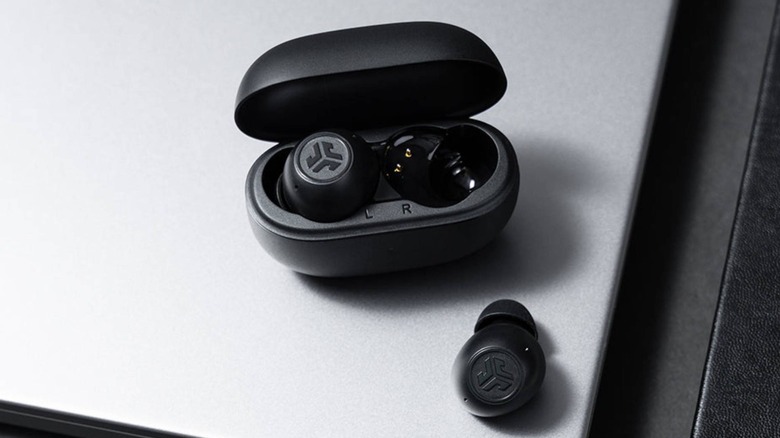 Top-down view of black JLab Go Pop ANC earbuds on a industrial silver background.