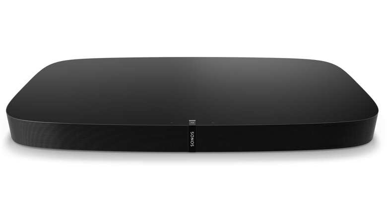 A Sonos Playbase soundbase positioned as a platform beneath a flat-screen television.