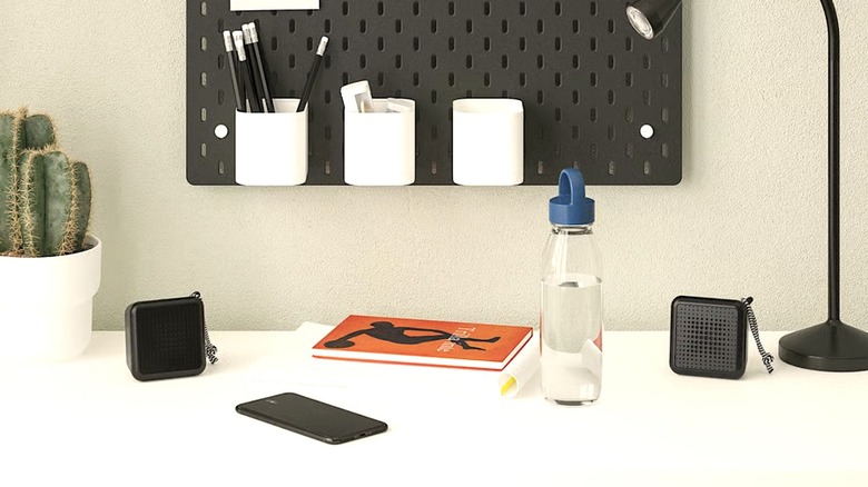 Two minimalist Vappeby Bluetooth speakers in black and white sitting on a clean desk surface.
