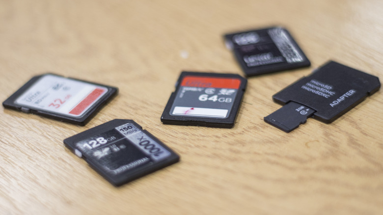 A collection of various SD and microSD cards on a wooden table.