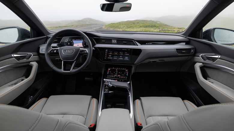 The luxury interior cabin of an Audi Q8 E-Tron as seen from the rear passenger area.