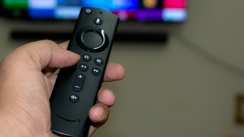 A hand holding the Fire TV remote control.