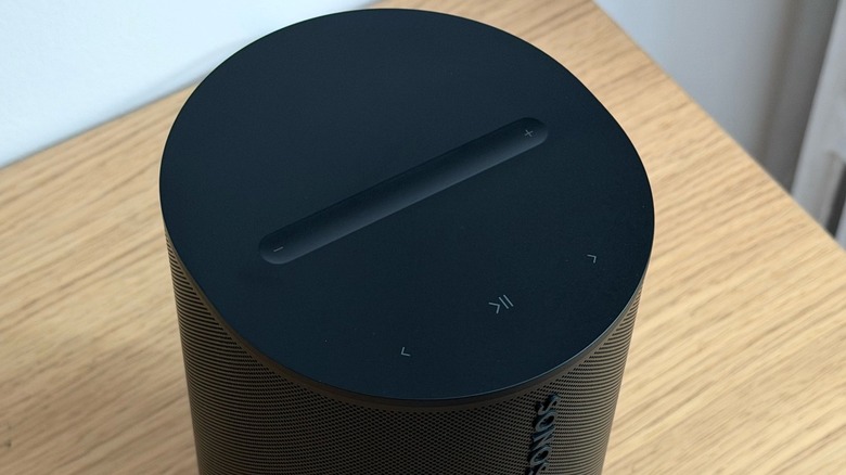Close-up of the top panel of the Sonos Era 100 SL showing volume and playback controls.
