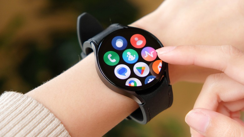 A smartwatch screen displaying a grid of various productivity and system app icons.