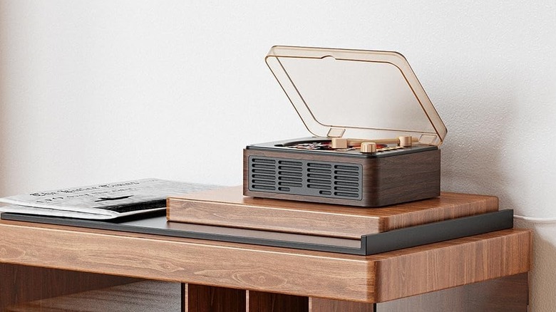 A wood-accented Caronsort CD player with Bluetooth speakers on a wooden shelf.