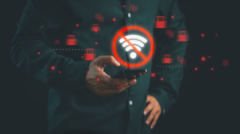 A person holding a smartphone with a glowing 'no Wi-Fi' error symbol on the screen.