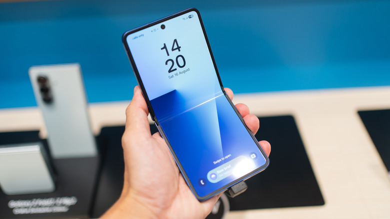 A close-up of the Samsung Galaxy Z Flip7 being held in a retail environment.