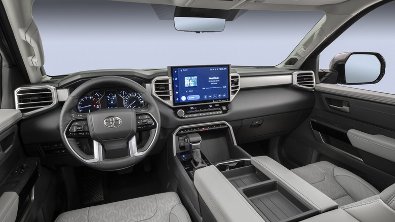 The modern interior of a 2024 Toyota Tundra featuring a large touchscreen and digital gauge cluster.