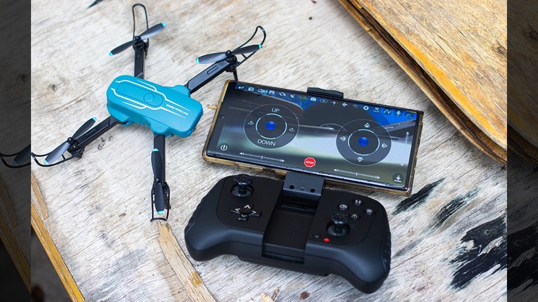 The Oviliee S17 controller with a smartphone attached, displaying the Oviliee FPV app interface.