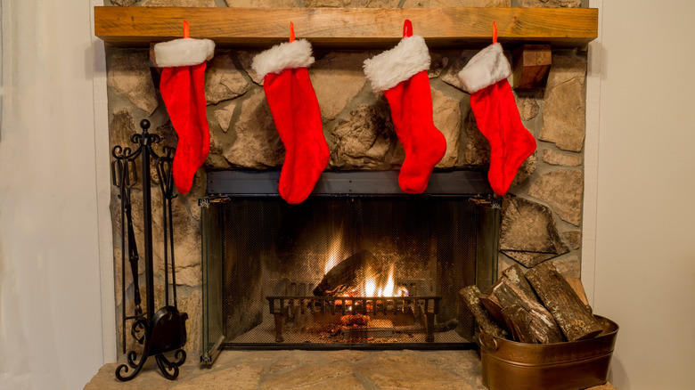 A classic red and white Christmas stocking hanging alone over a fireplace mantel.