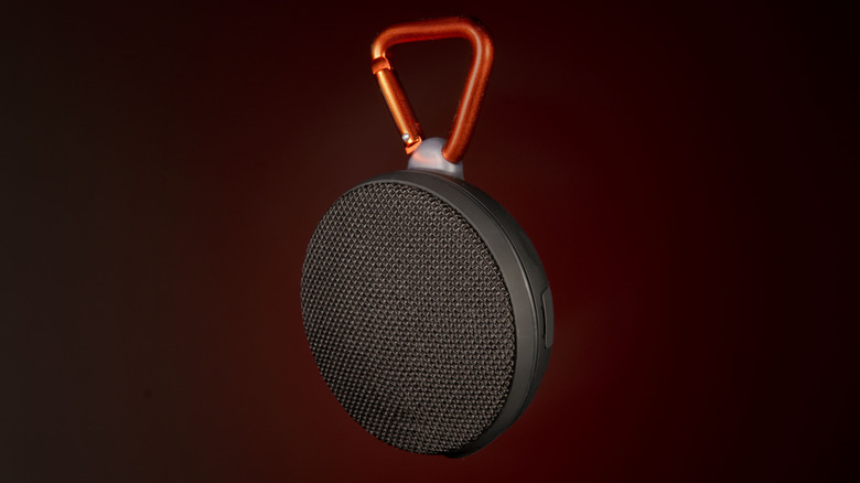 A rugged portable Bluetooth speaker with a heavy-duty metal clip for secure attachment to gear.
