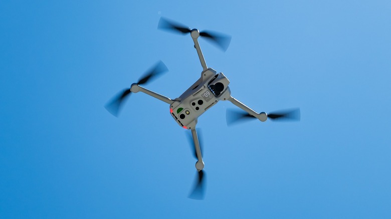 An upward-looking view of the Antigravity A1 drone flying against a bright blue sky.