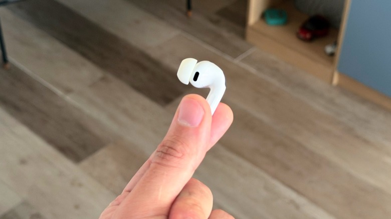 A hand holding a single AirPods Pro 3 earbud to show its compact design.