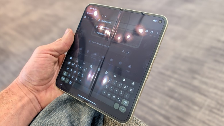 The Google Pixel 10 Pro Fold held open in a hand, showing the large internal screen.