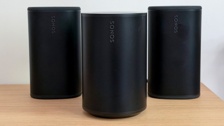 The Sonos Era 100 SL placed alongside older Sonos Play speakers.