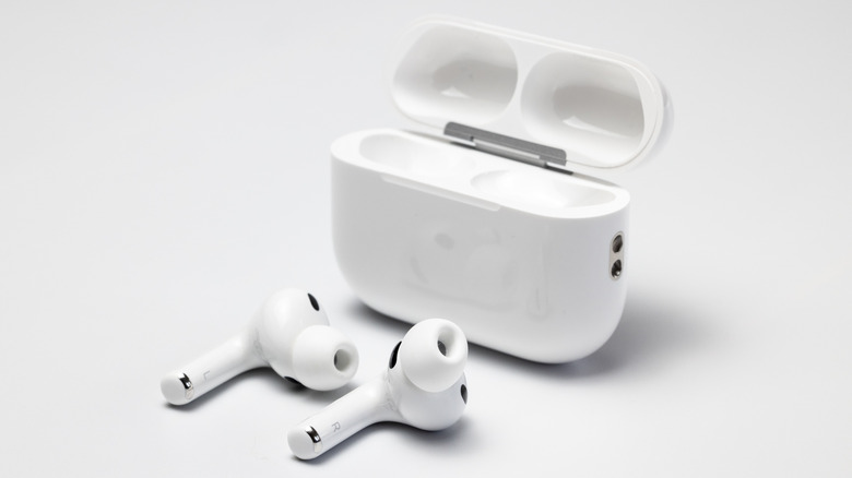 AirPods Pro earbuds sitting outside their open charging case.
