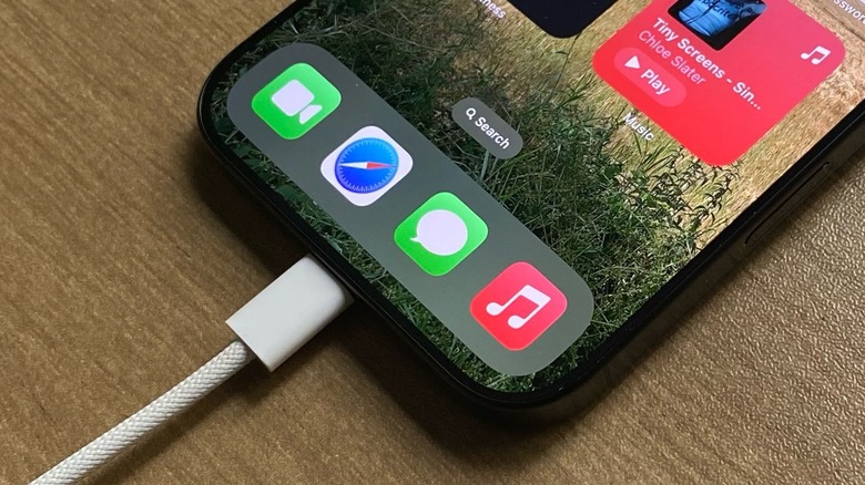 A USB-C connector being inserted into a mobile device.