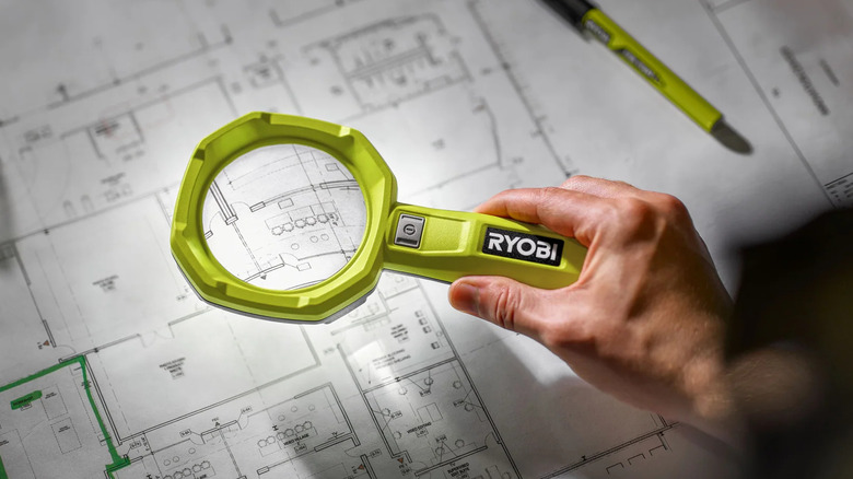 Ryobi USB Lithium Magnifying Light illuminating architectural blueprints on a workspace.