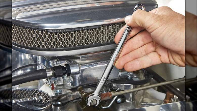 An Icon anti-slip grip professional wrench being used to adjust a vehicle throttle linkage.