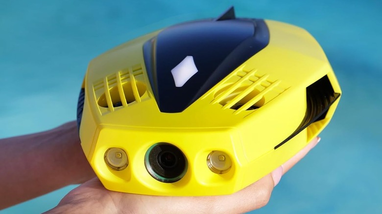 A person holding the compact Chasing Dory underwater drone in their hands to show its small size.