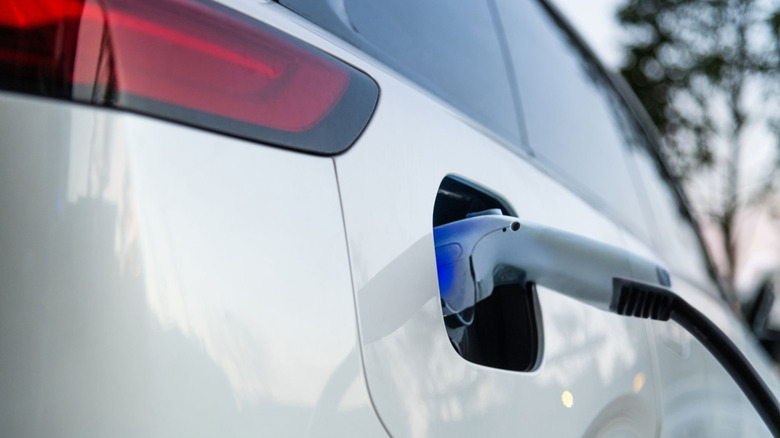 Close-up of a standard EV charging connector plugged into the vehicle's side charging port.