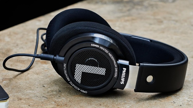 Philips SHP9500 open-back headphones on a beige-colored surface.